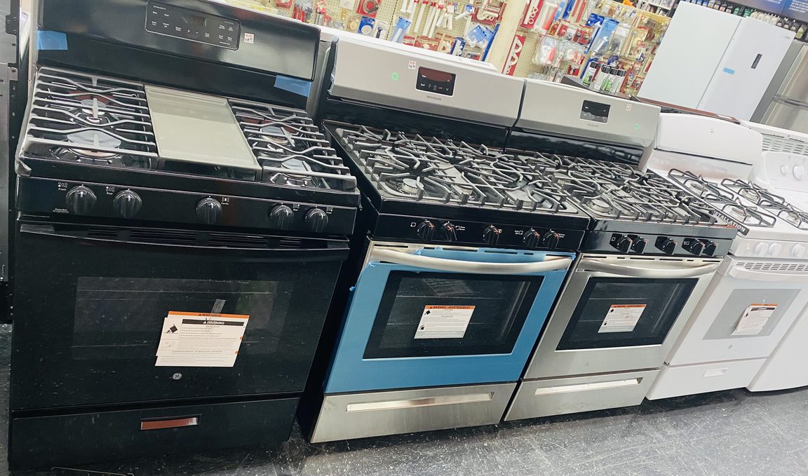 A row of kitchen ranges and refrigerators in the Wilde Auto Plus appliance showroom
