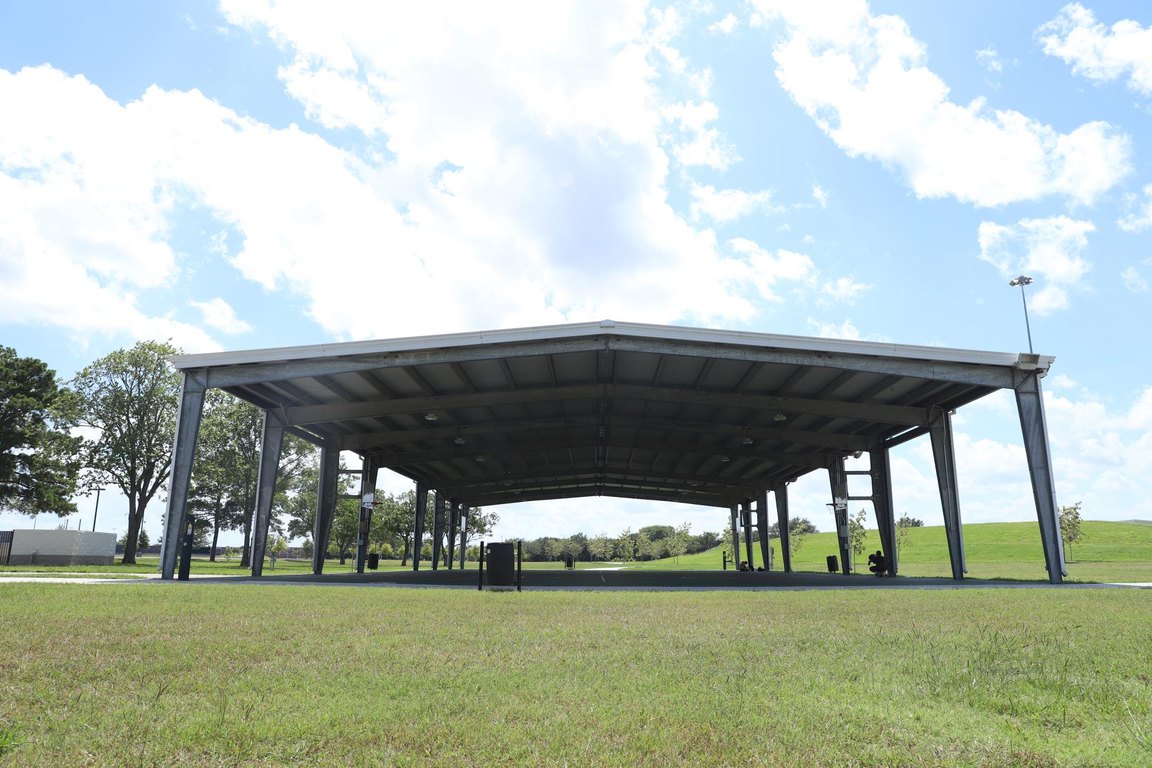 A large open-sided metal pavilion on a grassy lawn at Independence Park.