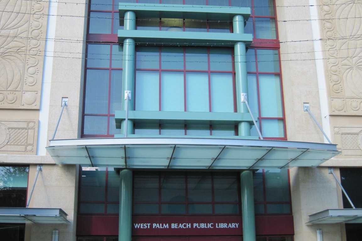 The glass and stone front entrance of the Mandel Public Library of West Palm Beach.