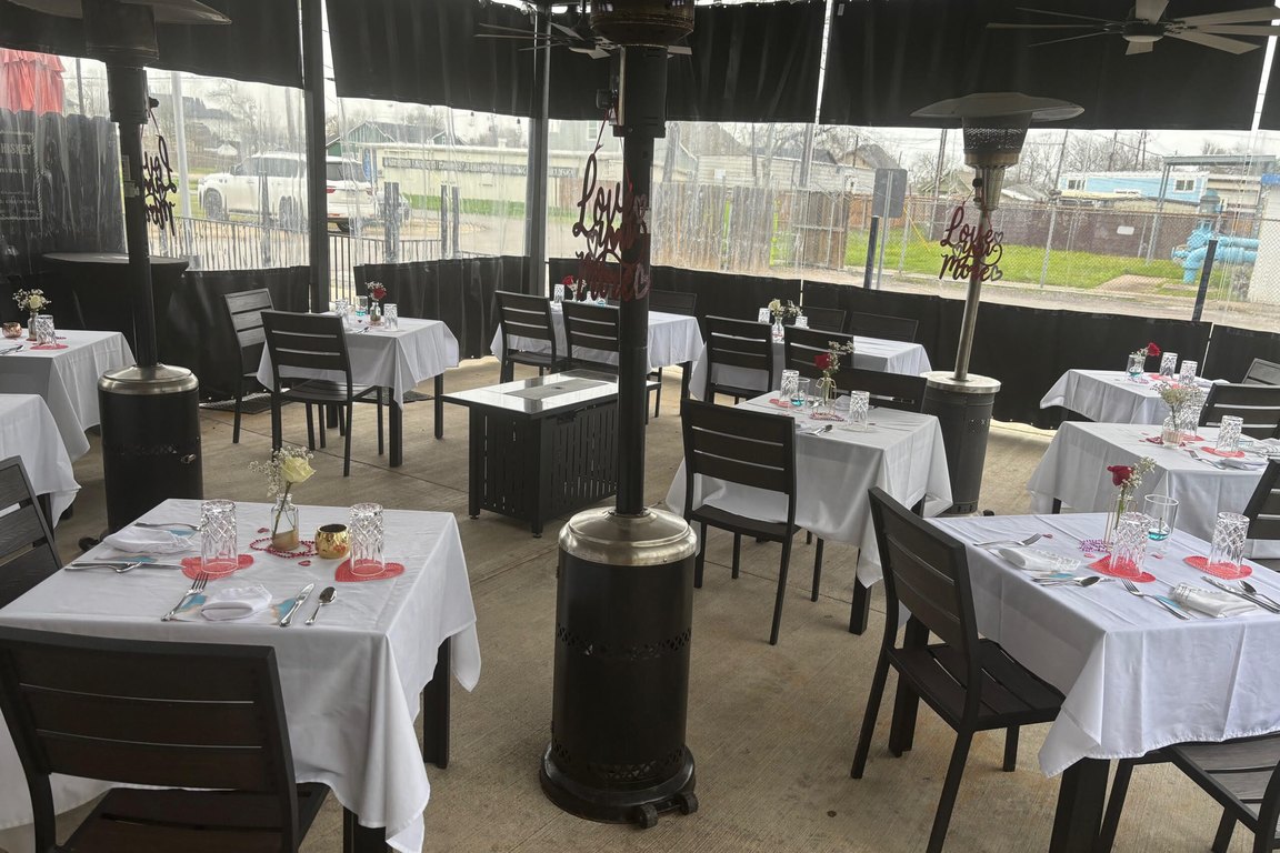 Tables set with white cloths on the covered patio at Ed's Bistro on Main.