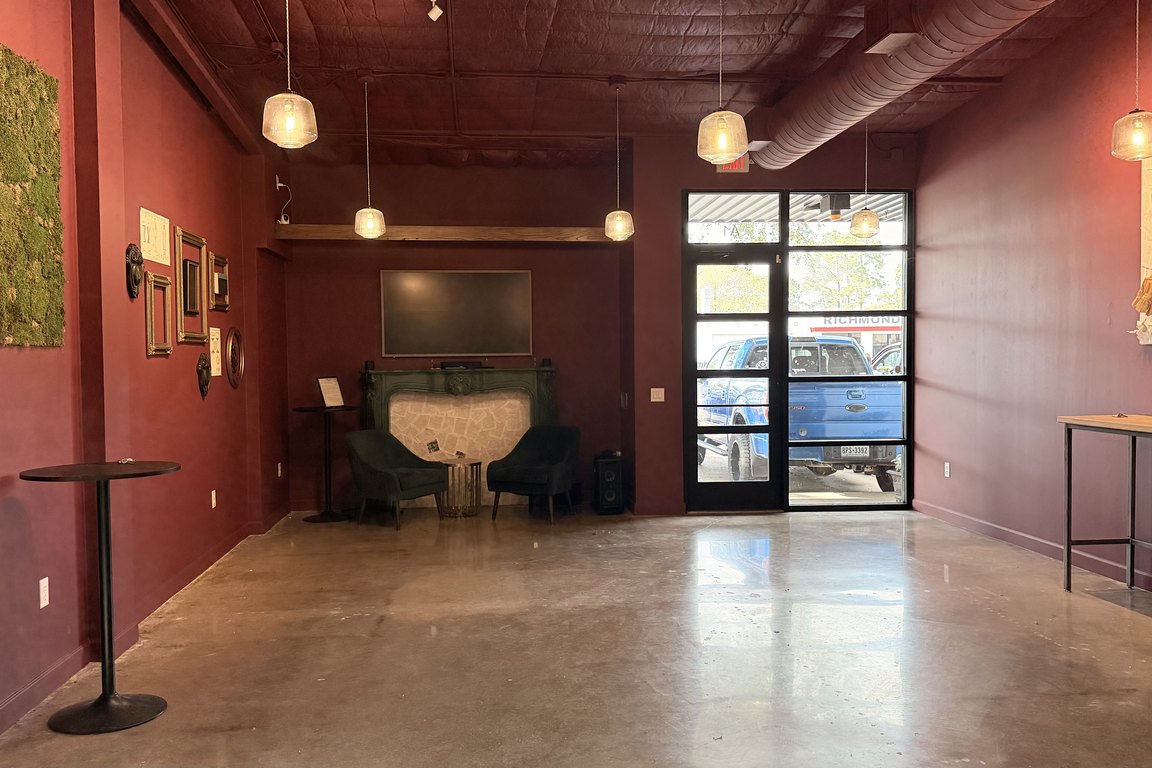 The Bookend’s event room on Jackson Street: an open space with burgundy walls, a concrete floor, bistro tables and a framed display of books on the wall