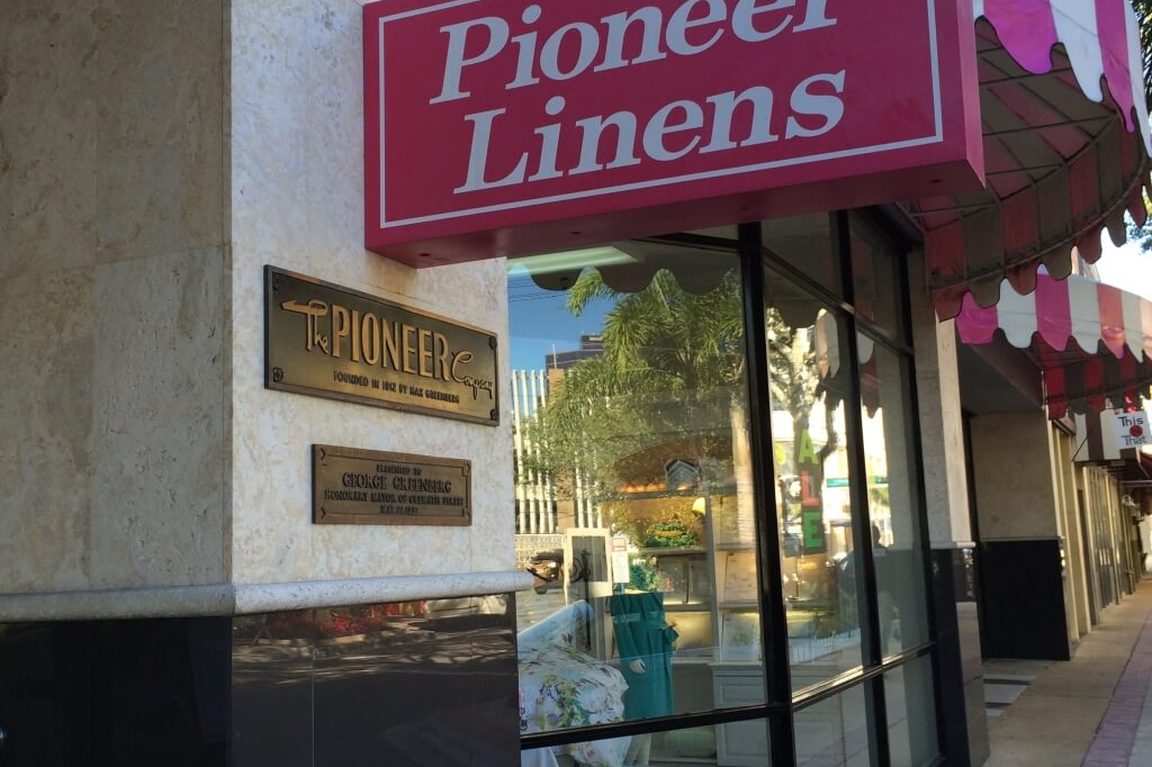 Pioneer Linens' pink sign and striped awning on Clematis Street